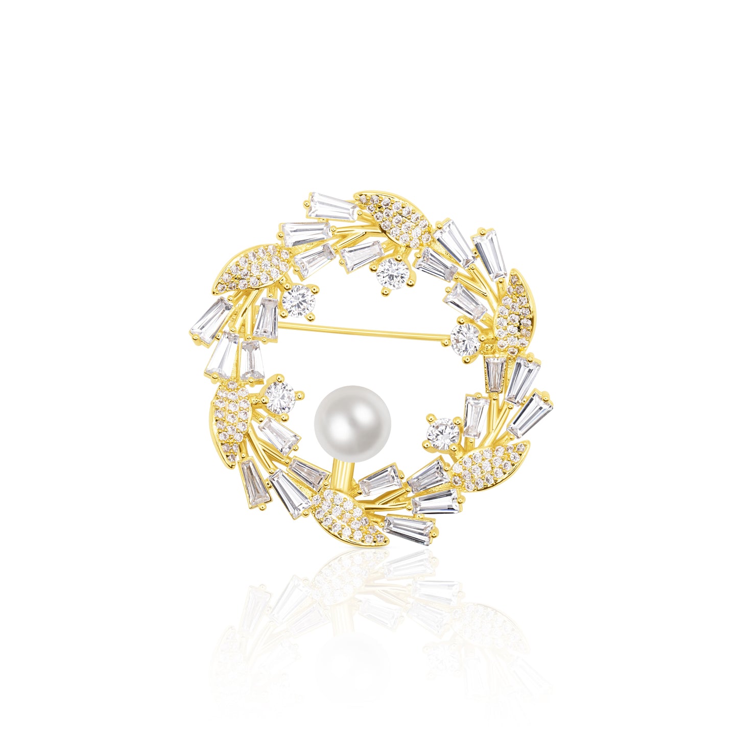 Circular Crystal Wreath Brooch with alternating clear baguette and round stones around a luminous pearl. The gold-plated setting highlights the contrast and symmetry of this festive, winter-ready accessory. Resting on a white reflective surface, it gleams with polished brilliance, making it ideal for holidays, formal events, or refined winter fashion.