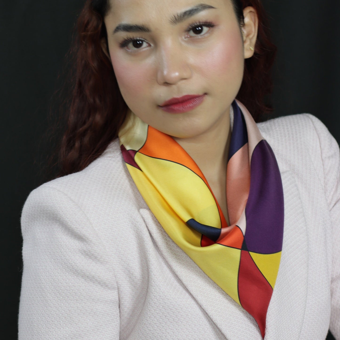 Woman wearing a colorful scarf against a black background