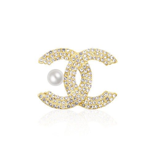 A glamorous gold-tone double C brooch encrusted with shimmering clear crystals, featuring a white faux pearl detail for added elegance. Stylish and iconic, this brooch is perfect for elevating both everyday and formal outfits with a luxurious flair.
