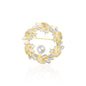 Circular Crystal Wreath Brooch with alternating clear baguette and round stones around a luminous pearl. The gold-plated setting highlights the contrast and symmetry of this festive, winter-ready accessory. Resting on a white reflective surface, it gleams with polished brilliance, making it ideal for holidays, formal events, or refined winter fashion.