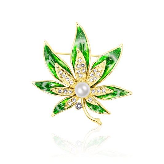 Stunning emerald green leaf brooch with gold-plated base, crystal accents, and intricate enamel detailing, perfect for adding a touch of nature to your style.