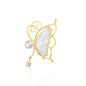 Whisperwing Butterfly Brooch featuring translucent white enamel wings framed in gold, a pearl body at the center, and a single teardrop crystal hanging delicately below. The piece rests on a white reflective background, highlighting its fairy-like elegance and subtle sparkle. A light and enchanting accessory perfect for weddings, spring events, or soft glam fashion.