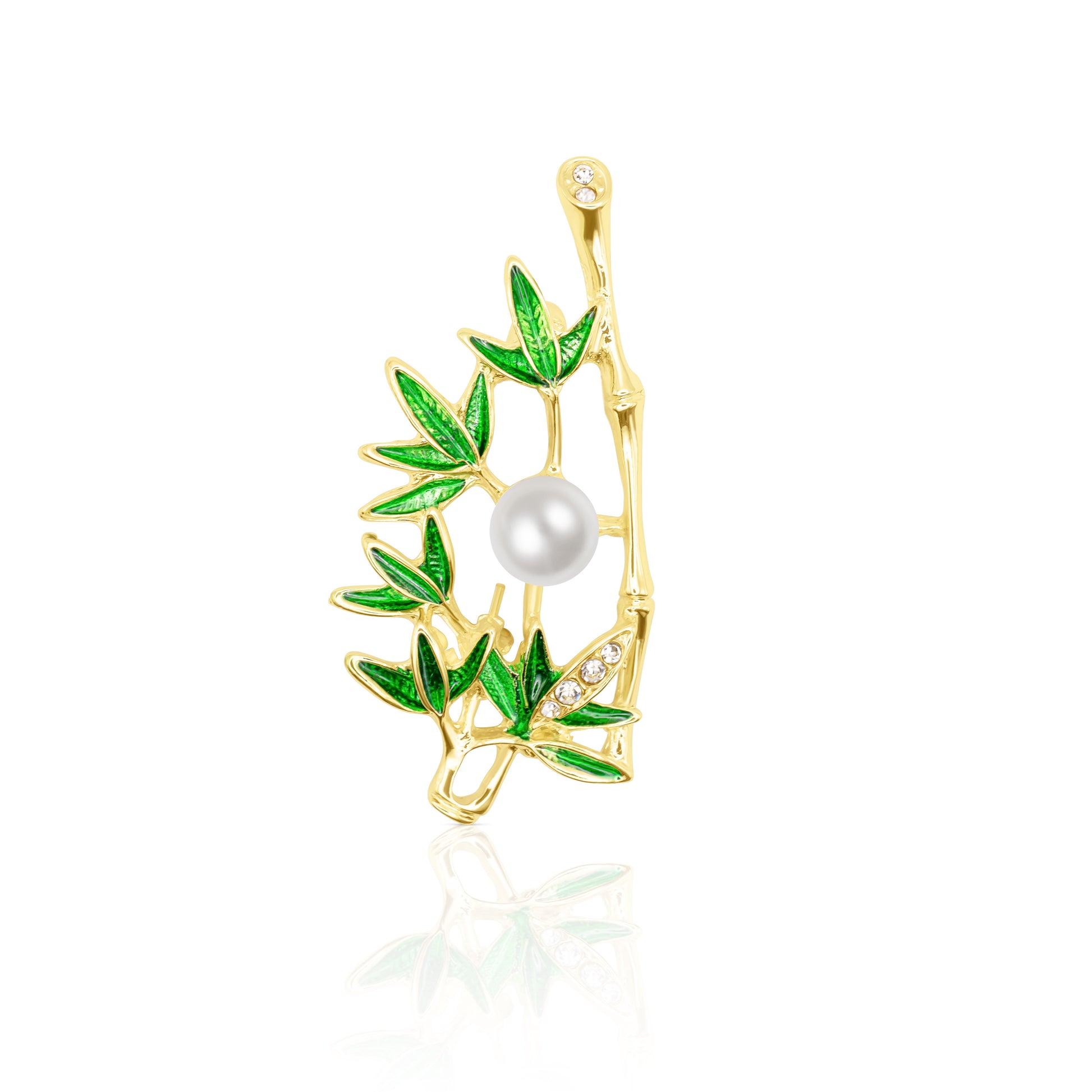 The Jade Whisper Brooch features a gold bamboo branch with lush green enamel leaves and a round pearl nestled at its center. Its vibrant foliage contrasts elegantly with the delicate white pearl. Photographed on a reflective white background, this nature-inspired pin radiates balance and vitality, making it an ideal piece for those drawn to earthy aesthetics and minimalist nature symbolism.