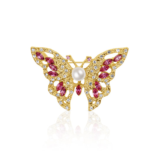 A stunning butterfly-shaped brooch with gold-tone detailing, featuring sparkling pink crystals and a central pearl, perfect for adding a whimsical touch to any outfit.