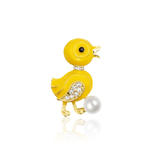 A playful yellow enamel duckling brooch with gold-plated edges, orange beak, and a faux pearl accent below. Whimsical and cheerful in design, this accessory is perfect for animal lovers or those looking to add a joyful pop to their wardrobe. Photographed against a light background to highlight the vivid enamel colors and shine.