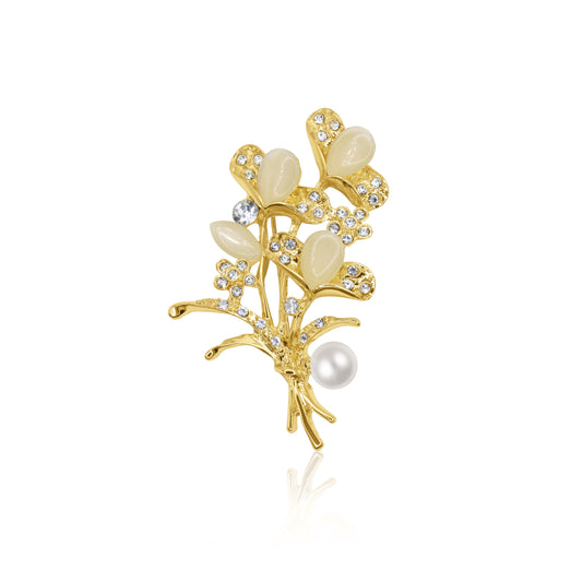 A charming bouquet-style brooch adorned with white enamel petals, sparkling crystals, and a central faux pearl. The gold-tone base and secure pin closure make it an exquisite accessory for weddings and special occasions.